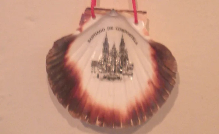 A scallop shell with Santiago de Compostella text